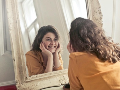 photo of woman looking at the mirror
